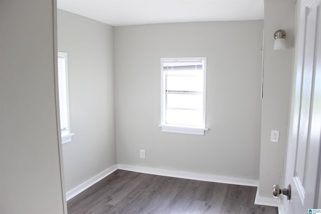 spare room with dark wood-style floors and baseboards