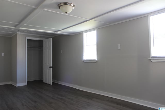 unfurnished bedroom with dark wood-type flooring, baseboards, and a closet