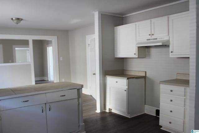 kitchen featuring under cabinet range hood, dark wood-type flooring, white cabinets, and light countertops