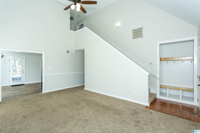 unfurnished living room featuring stairway, carpet flooring, a ceiling fan, and visible vents