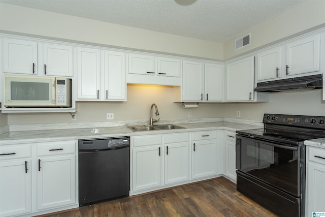 kitchen with visible vents, under cabinet range hood, white cabinets, black appliances, and a sink