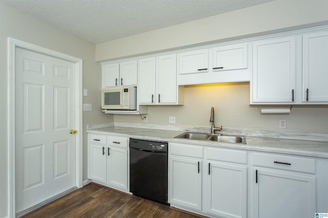 kitchen featuring white microwave, light countertops, black dishwasher, white cabinetry, and a sink