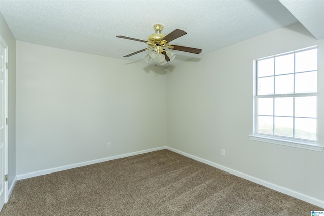 spare room featuring a textured ceiling, baseboards, dark carpet, and ceiling fan