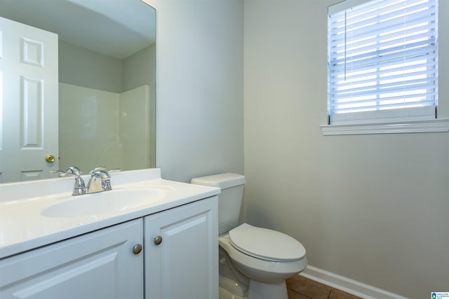 bathroom featuring tile patterned flooring, toilet, vanity, and baseboards