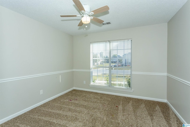 carpeted spare room featuring visible vents, baseboards, a textured ceiling, and a ceiling fan