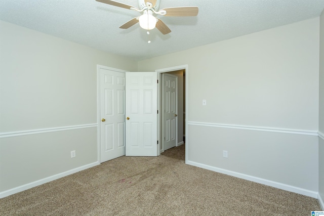 unfurnished bedroom featuring ceiling fan, baseboards, carpet floors, and a textured ceiling