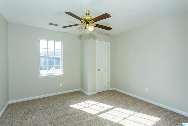 spare room featuring visible vents, baseboards, carpet, and a ceiling fan