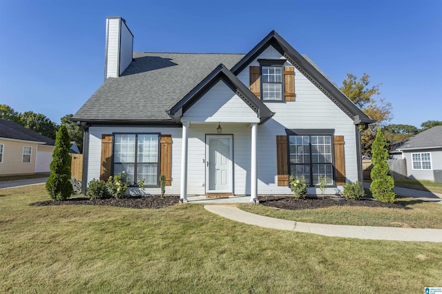 view of front of property featuring a shingled roof, a front yard, and a chimney