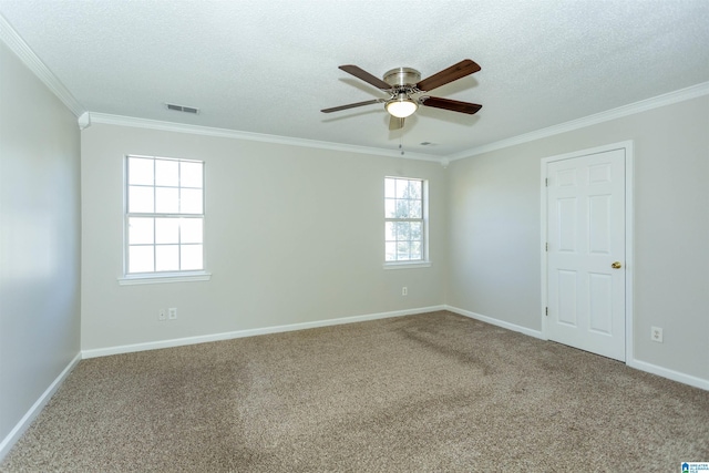 carpeted spare room featuring visible vents, a ceiling fan, a textured ceiling, crown molding, and baseboards