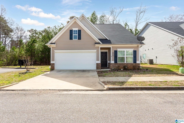 craftsman house with a front lawn, driveway, cooling unit, an attached garage, and brick siding