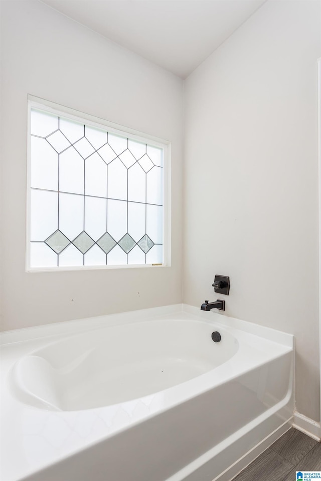 bathroom featuring a bath and a healthy amount of sunlight