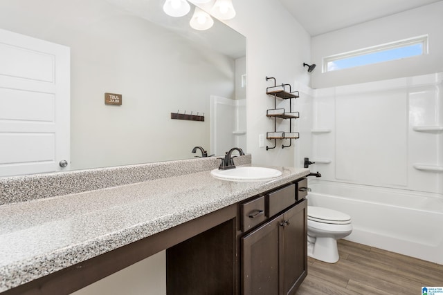 full bathroom with toilet, wood finished floors, vanity, and shower / tub combination