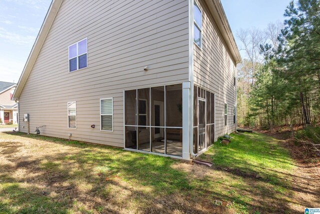 back of house with a lawn and a sunroom