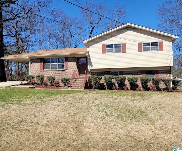 split level home with brick siding, an attached carport, driveway, and a front yard