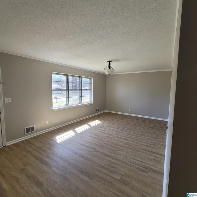 unfurnished room with crown molding, visible vents, and dark wood-style flooring