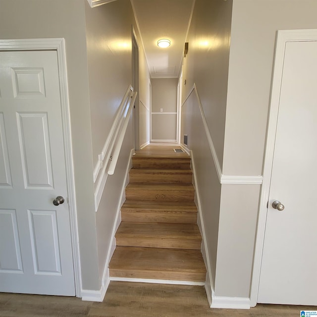 stairway featuring baseboards, attic access, and wood finished floors