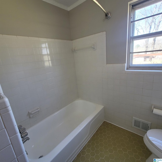 full bath featuring tile patterned floors, visible vents, toilet, tile walls, and bathing tub / shower combination