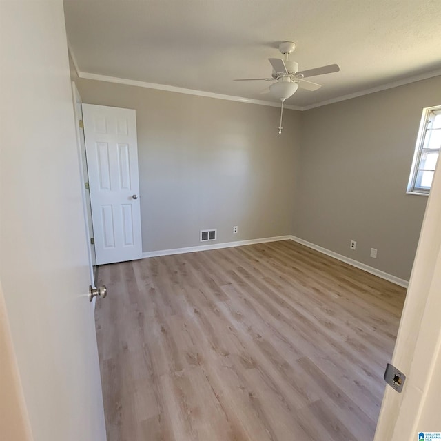 spare room with visible vents, baseboards, a ceiling fan, and ornamental molding