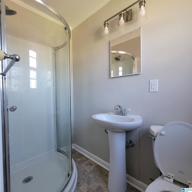 full bath featuring toilet, baseboards, a stall shower, and a sink