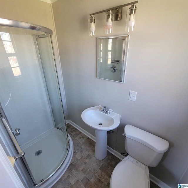 full bath featuring baseboards, toilet, a stall shower, and stone finish floor