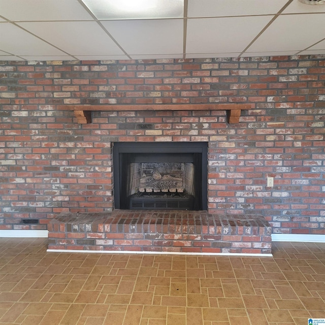 interior details with a drop ceiling and a fireplace