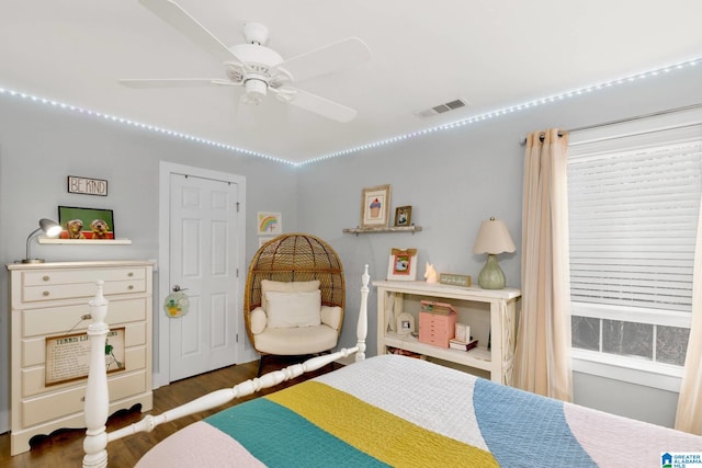 bedroom with a ceiling fan, wood finished floors, and visible vents