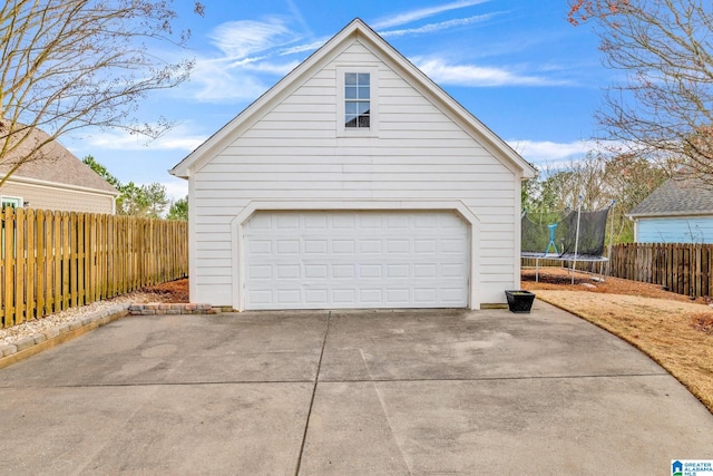 garage featuring a trampoline and fence