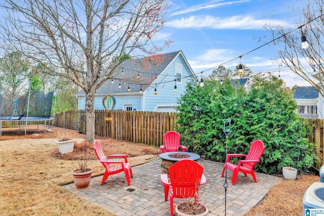 view of patio / terrace with a trampoline, a fire pit, and a fenced backyard