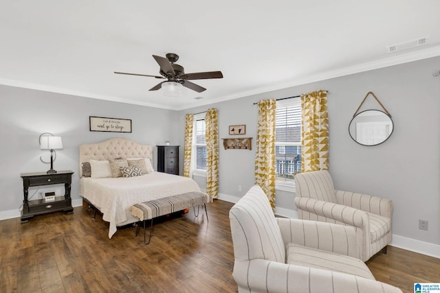 bedroom featuring visible vents, baseboards, wood finished floors, and crown molding