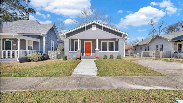 bungalow-style home featuring a front lawn, a gate, fence, and covered porch