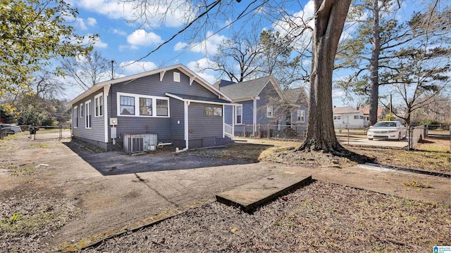 rear view of property with cooling unit and fence