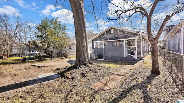 rear view of house featuring central AC and fence