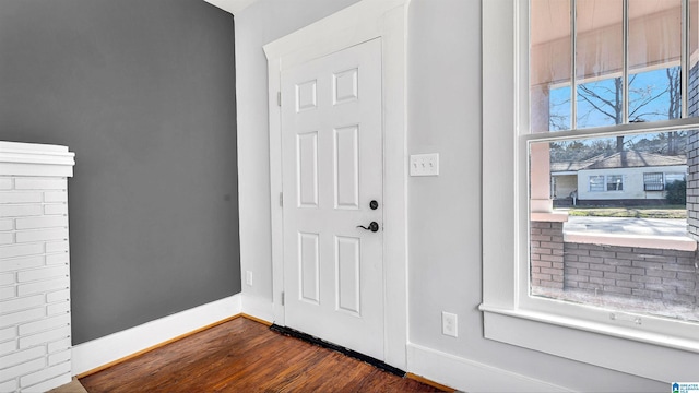 foyer entrance with dark wood finished floors and baseboards