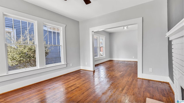 unfurnished living room featuring baseboards, ceiling fan, and hardwood / wood-style flooring