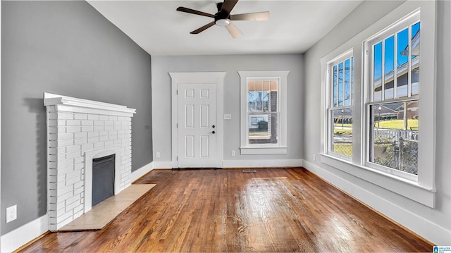 unfurnished living room featuring hardwood / wood-style flooring, a fireplace, baseboards, and ceiling fan