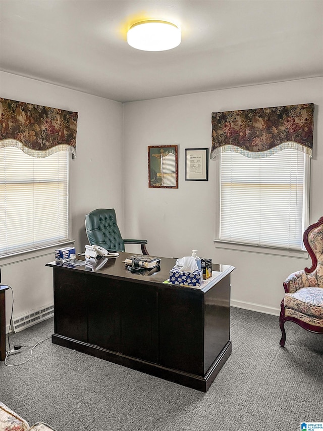 carpeted office space with a baseboard heating unit and baseboards