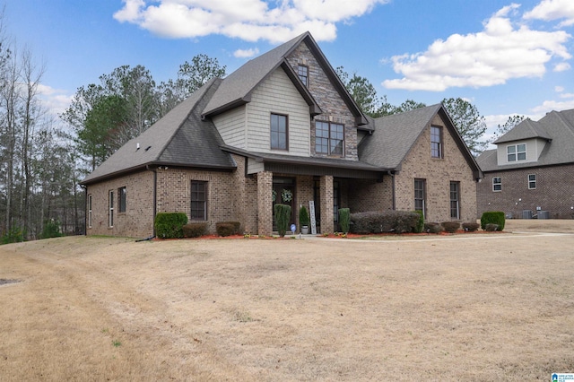 view of front of house with brick siding and a shingled roof