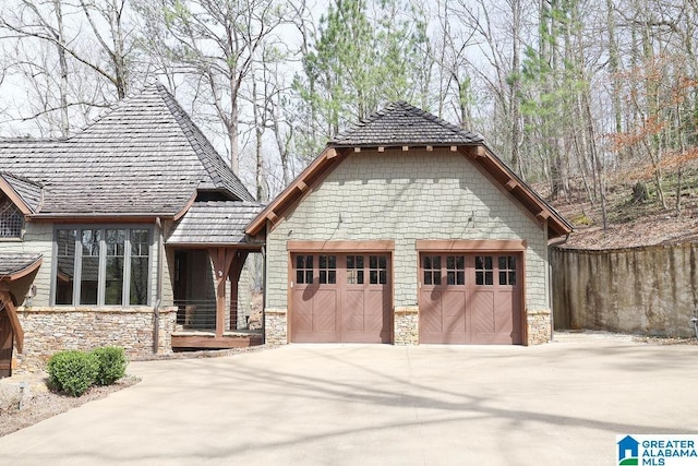 view of front facade with a garage, stone siding, and driveway