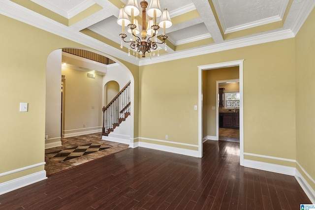 unfurnished room featuring a notable chandelier, wood finished floors, arched walkways, and baseboards