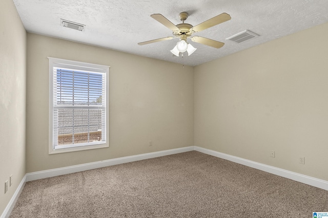 carpeted spare room with visible vents, a textured ceiling, baseboards, and a ceiling fan