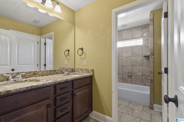 bathroom with a sink, visible vents, baseboards, and a textured ceiling