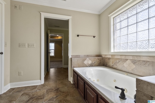 bathroom with baseboards, a jetted tub, and crown molding