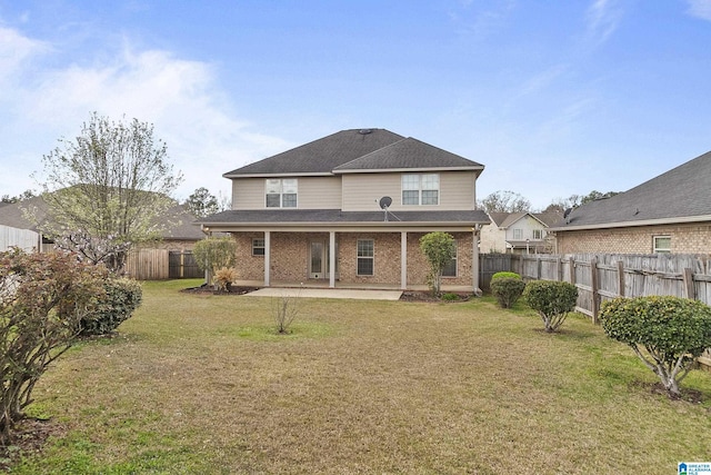 back of property featuring a patio, a fenced backyard, a yard, roof with shingles, and brick siding