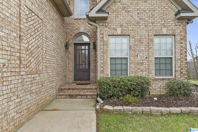 view of exterior entry with brick siding