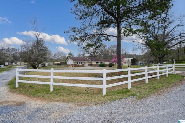 view of front of home featuring gravel driveway and a fenced front yard