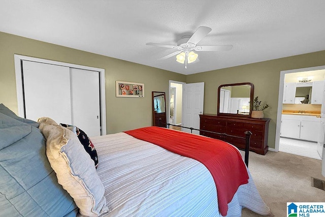 bedroom featuring visible vents, light carpet, a closet, a textured ceiling, and a ceiling fan