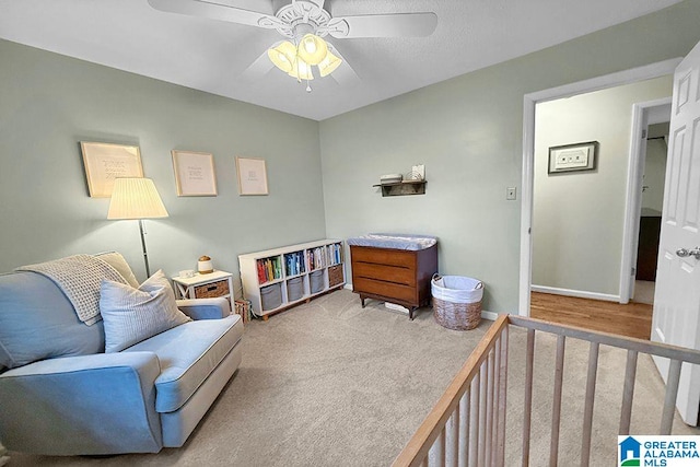 living area with carpet flooring, baseboards, and a ceiling fan