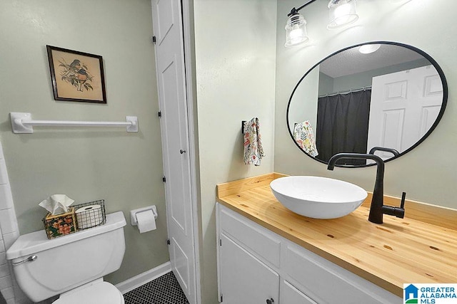 bathroom featuring vanity, toilet, and baseboards