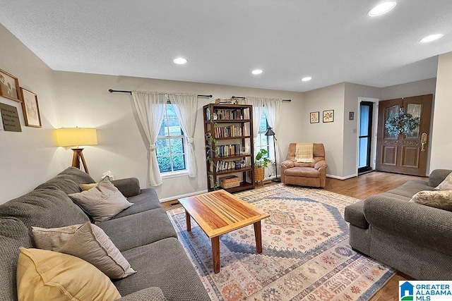 living area featuring recessed lighting, baseboards, and wood finished floors