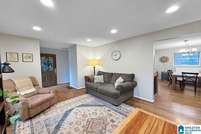 living area featuring a notable chandelier, recessed lighting, baseboards, and wood finished floors